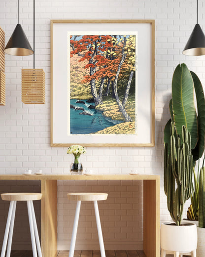 Lyrea art print in a black frame above a coffee shop counter with a white brick wall and pendant lights