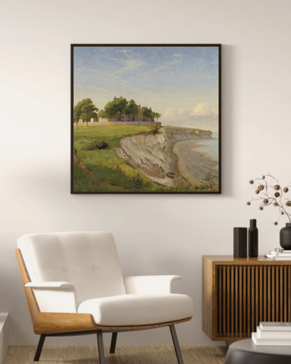 Hojerup Church art print in a black square frame above a mid-century armchair and wood sideboard