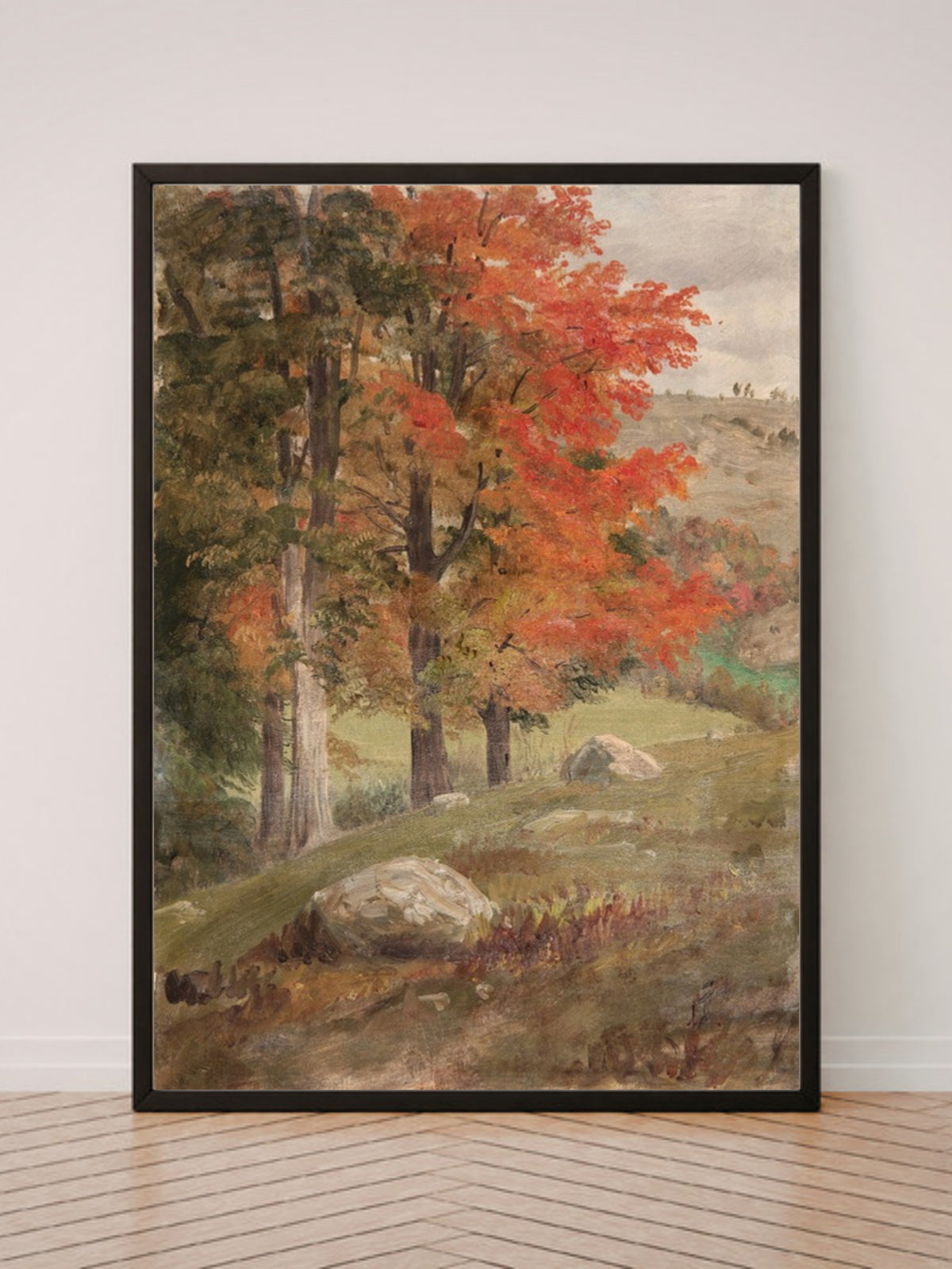 Woods in Autumn art print in a black frame, leaning against a white wall on a wood floor