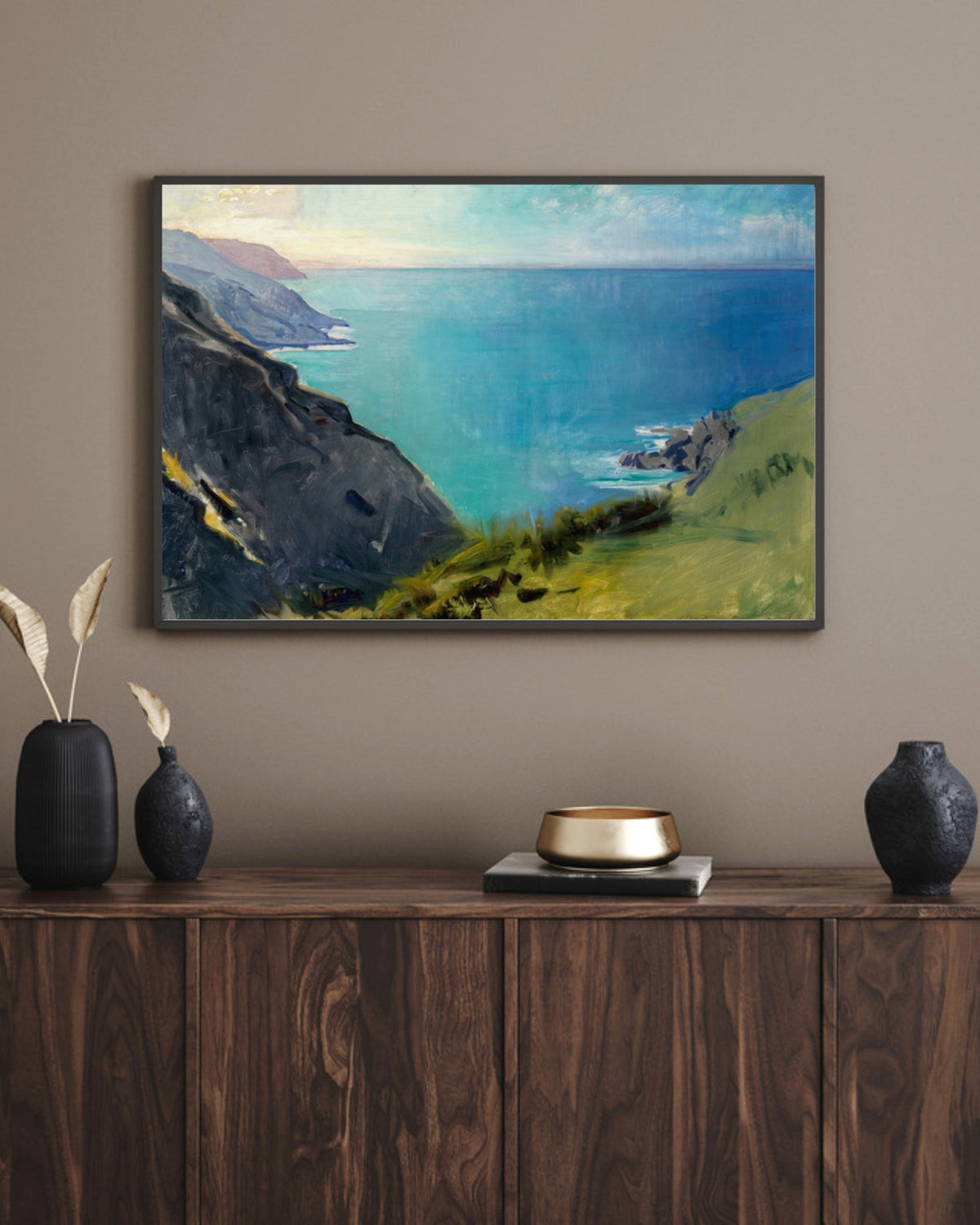 Cornish Headlands art print in a black landscape frame above a walnut sideboard