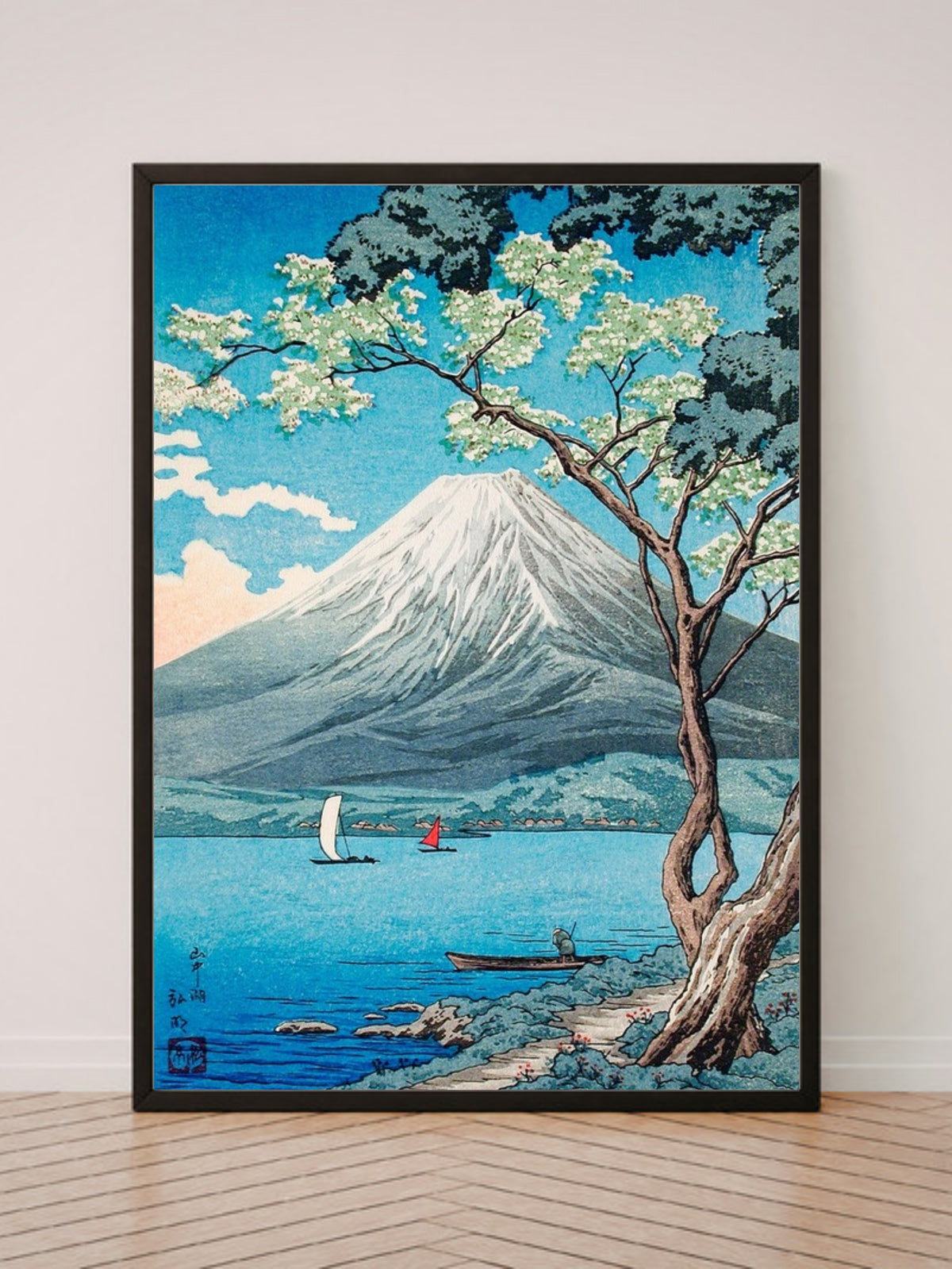 Mount Fuji from Lake Yamanaka art print in a black frame, leaning against a white wall on a wood floor