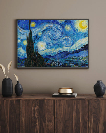 The Starry Night art print in a black landscape frame above a walnut sideboard